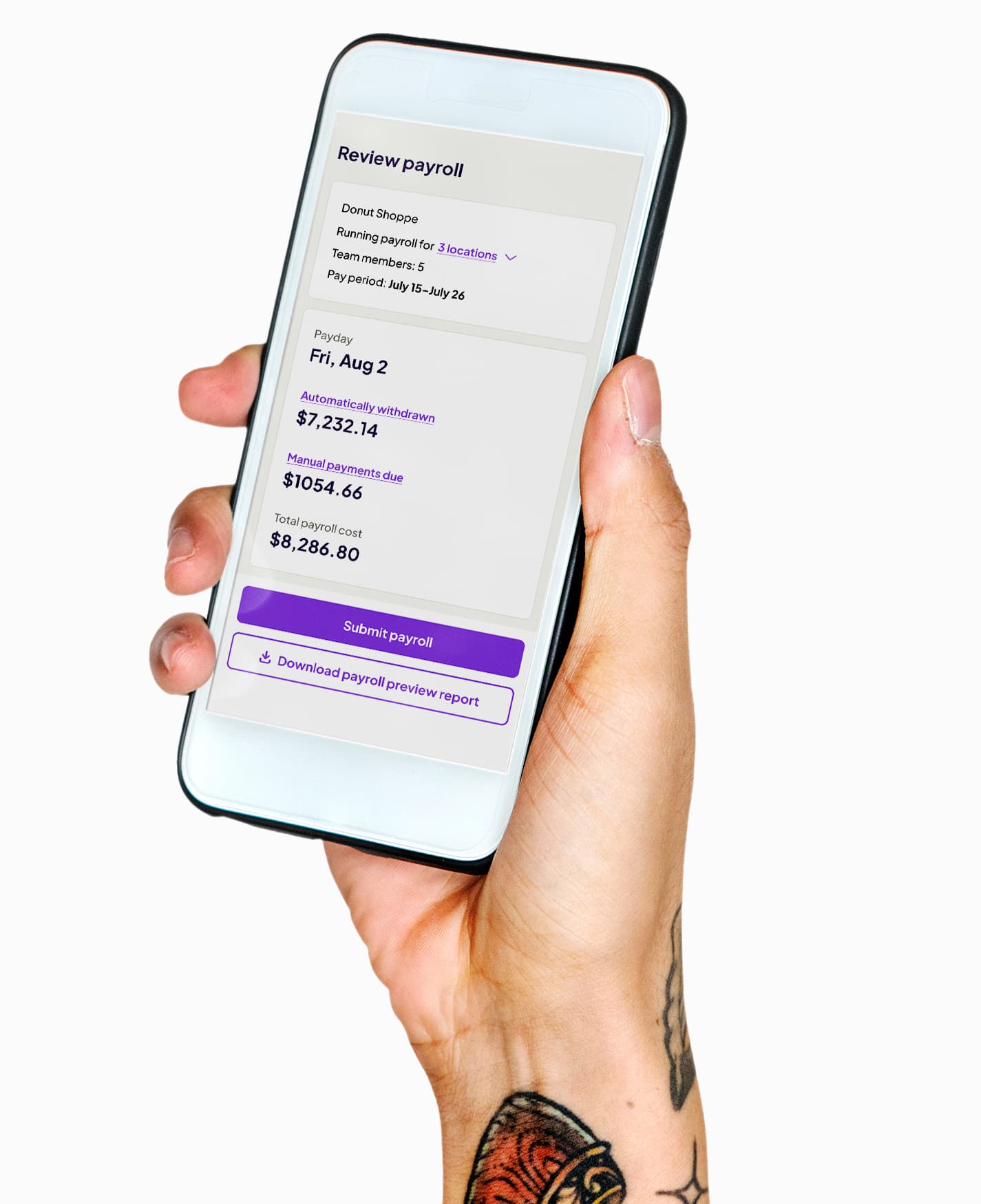 Hand with tattoos holding a smartphone displaying a payroll review screen for Donut Shoppe with payroll details and submit button.