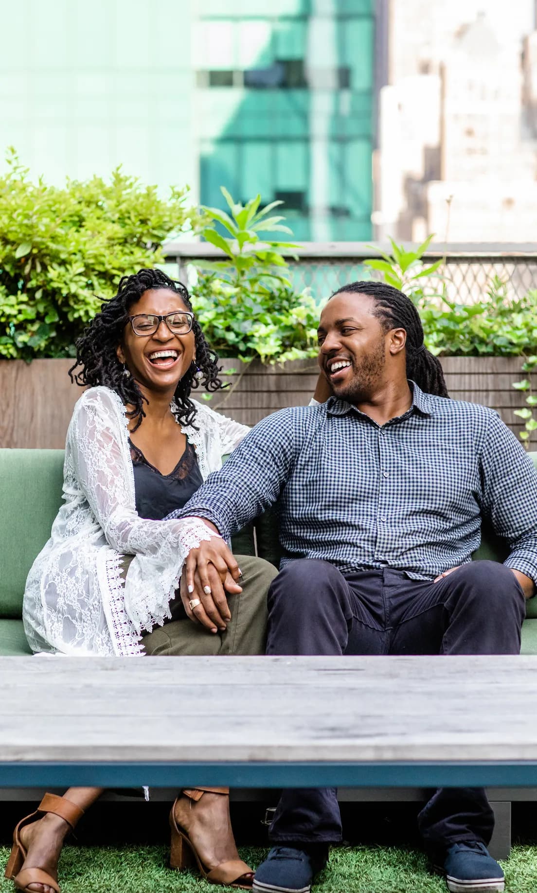 Two Brooklyn Tea co-owners laughing together on a rooftop bench.