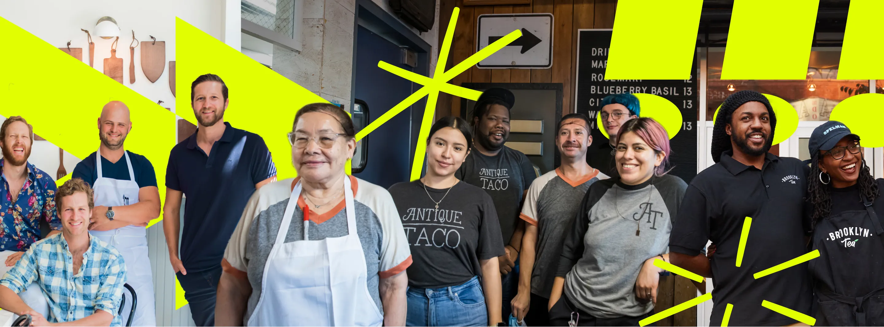 Diverse group of smiling restaurant and cafe staff posing together indoors, wearing aprons and branded shirts.