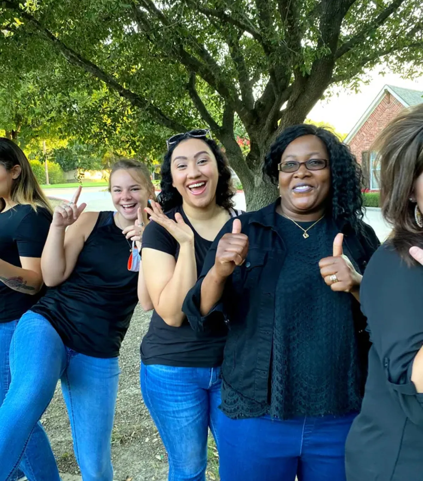 A preschool staff team smiling together outdoors