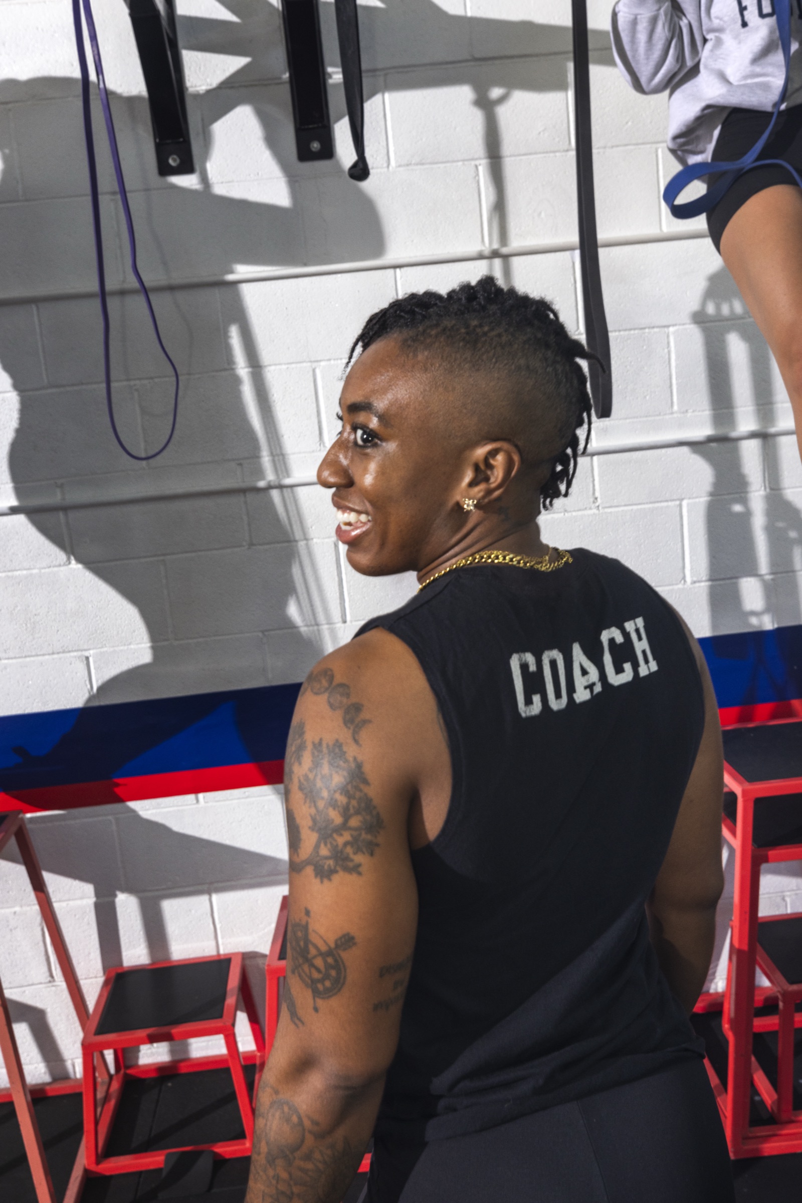 An F45 fitness coach smiling during a group workout session