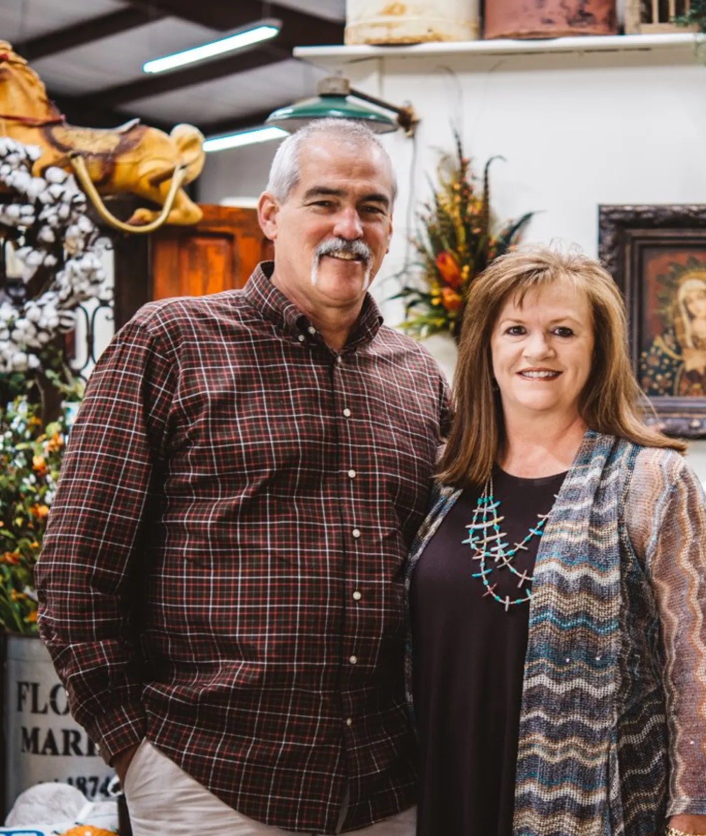 A retail shop owner couple smiling inside their store